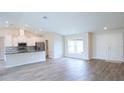 Bright, open-concept living area with wood-look tile flooring and plenty of natural light at 13098 Convent Garden Rd, Brooksville, FL 34614