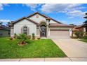 Beautiful one-story home featuring manicured lawn, attractive landscaping, and a convenient two-car garage at 13523 Meadow Golf Ave, Hudson, FL 34669
