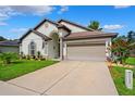 Inviting one-story home with a well-kept lawn, pretty landscaping, and a practical two-car garage at 13523 Meadow Golf Ave, Hudson, FL 34669