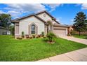 Well-maintained one-story home with a two-car garage, beautiful lawn, and attractive landscaping at 13523 Meadow Golf Ave, Hudson, FL 34669