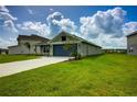 Well-maintained home showcasing lush green lawn and attached two-car garage at 16433 66Th E Ln, Parrish, FL 34219