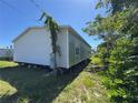 Exterior view showing the side of the home with natural landscape and blue skies at 205 Portia S St, Nokomis, FL 34275