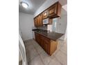 Kitchen features wooden cabinets, granite countertops, stainless steel sink and microwave at 226 Thorn Tree Pl # 226, Brandon, FL 33510