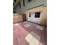 Private outdoor patio with red and beige patterned tile and a small back door at 226 Thorn Tree Pl # 226, Brandon, FL 33510
