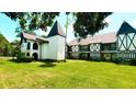 Unique Tudor-style condo with black and white details, complemented by a lush green lawn and mature trees at 230 N Bayshore Blvd # 103, Clearwater, FL 33759