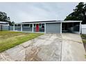 Charming single-story home featuring a bright red front door and covered front patio at 2419 Wishing Well Way, Tampa, FL 33619