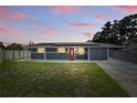 Inviting single-story home with gray exterior, red door, solar panels, and well-manicured front lawn at 2419 Wishing Well Way, Tampa, FL 33619