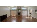 Bright living room with fireplace, vaulted ceilings, and wood floors, perfect for relaxing or entertaining at 2635 Jarvis Cir, Palm Harbor, FL 34683