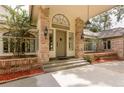 Elegant entryway featuring brick pillars, outdoor lanterns, and arched window at 3042 Oak Creek N Dr, Clearwater, FL 33761