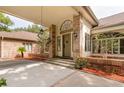 Welcoming front porch with brick pillars, stylish sconces, and manicured landscaping at 3042 Oak Creek N Dr, Clearwater, FL 33761