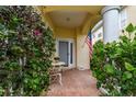 Cozy front porch with a decorative table, blooming flowers, and an American flag at 3484 Primrose Way, Palm Harbor, FL 34683