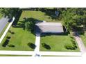 A bird's eye view shows the property with a sprawling green lawn and a quaint shed nestled in the back at 38320 14Th Ave, Zephyrhills, FL 33542