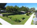 A beautifully landscaped yard surrounds a home with mature trees offering shade and curb appeal at 38320 14Th Ave, Zephyrhills, FL 33542