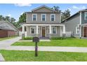 Attractive two-story home showcasing a covered front porch with decorative pillars and lush lawn at 406 E Selma Ave, Tampa, FL 33603