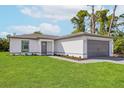 Single-story home with a well-manicured lawn, neutral color scheme, and attached two-car garage at 4625 Vernell St, North Port, FL 34291