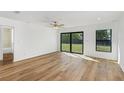 A bright living room with wood-look floors, a ceiling fan, and sliding glass doors to the backyard at 4625 Vernell St, North Port, FL 34291