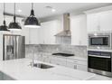 Modern kitchen featuring white cabinets, stainless steel appliances, and a quartz countertop island at 4773 Hickory Oak Dr, Brooksville, FL 34601