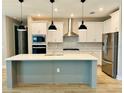 Modern kitchen featuring white cabinets, stainless steel appliances, and a large island at 4773 Hickory Oak Dr, Brooksville, FL 34601
