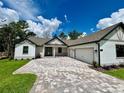Beautiful home featuring a paved driveway, attached 2 car garage, and pristine landscaping at 4799 Hickory Oak Loop, Brooksville, FL 34601