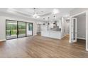 Bright open concept living room featuring hardwood floors, ceiling fan, sliding doors, and an island with pendant lights at 4799 Hickory Oak Loop, Brooksville, FL 34601