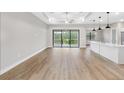 Bright open concept living room featuring hardwood floors, ceiling fan, sliding doors, and an island with pendant lights at 4799 Hickory Oak Loop, Brooksville, FL 34601