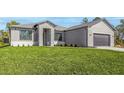 Well-maintained single-story house features a lush green lawn and a contemporary exterior at 5104 Munhal St, Port Charlotte, FL 33981