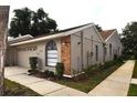 Single story villa featuring a brick accent, neutral colored exterior and well manicured landscaping at 5530 Salem Square N Dr, Palm Harbor, FL 34685