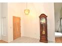 Bright foyer showcasing tile flooring, modern lighting and an antique grandfather clock at 5530 Salem Square N Dr, Palm Harbor, FL 34685