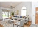 Bright living room with vaulted ceilings, large windows, and a ceiling fan at 5530 Salem Square N Dr, Palm Harbor, FL 34685