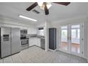 Bright kitchen with stainless steel appliances, white cabinets, and a view of the sunroom through French doors at 6497 43Rd N Ave, Kenneth City, FL 33709