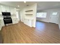 Open-concept kitchen features stainless steel appliances, white cabinets, and modern wood-look flooring at 814 19Th Sw St, Largo, FL 33770