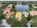 Beautiful aerial view of a neighborhood showcasing a central lake and well-maintained homes with lush landscaping at 9800 Sago Point Dr, Seminole, FL 33777