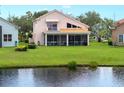 Scenic backyard view featuring a screened-in porch and a tranquil pond, creating a serene outdoor space at 9800 Sago Point Dr, Seminole, FL 33777