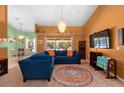 A cozy living room with an ornate chandelier, stylish furnishings, and lots of natural light at 10228 Yellow Pine Way, Hudson, FL 34667