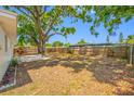 Large backyard with mature tree, wood fence, and patio area perfect for outdoor activities and entertaining at 10599 111Th N Ave, Largo, FL 33773