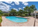 Inviting backyard pool surrounded by lush landscaping and a brick patio, perfect for outdoor relaxation and entertaining at 10611 131St St, Largo, FL 33774