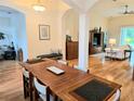 Open-concept dining room with hardwood floors, a large table, and elegant decor at 10621 Ribbon Fern Way Way, Land O Lakes, FL 34638