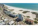 Aerial view of beach condo building with lush sandy beach and beautiful view of the Gulf of Mexico at 11000 Gulf Blvd # 703, Treasure Island, FL 33706