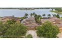 Aerial view of home with backyard landscaping, lake view, and solar panels at 11603 Heron Watch Pl, Riverview, FL 33569