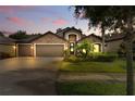 Charming single-Gathering home featuring a stone facade, three-car garage, and lush landscaping at 12729 Flatwood Creek Dr, Gibsonton, FL 33534
