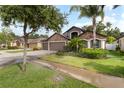 Charming single-Gathering home featuring a stone facade, three-car garage, and lush landscaping at 12729 Flatwood Creek Dr, Gibsonton, FL 33534