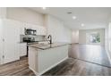 Modern kitchen featuring stainless steel appliances, granite countertops, and an island with a sink at 13016 Boggy Creek Dr, Riverview, FL 33579