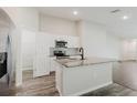 Modern kitchen featuring stainless steel appliances, granite countertops, and an island with sink at 13016 Boggy Creek Dr, Riverview, FL 33579