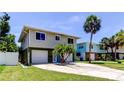 Two-story home featuring a spacious driveway, and complemented by a palm tree at 1858 Michigan Ne Ave, St Petersburg, FL 33703