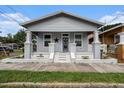Charming single-story home with a welcoming front porch and a well-maintained lawn at 1902 N Tampania Ave, Tampa, FL 33607