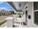 Inviting front porch with stylish accents, a welcome mat, and a clear view of the quiet neighborhood at 1902 N Tampania Ave, Tampa, FL 33607