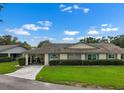 Well-kept single-story home with a carport and neat front lawn with manicured hedges at 2006 Hadrian Ct, Sun City Center, FL 33573