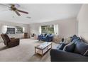 Cozy living room with plush sofas, neutral carpeting, and bright natural light from windows at 2006 Hadrian Ct, Sun City Center, FL 33573