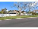 Side view of home, showcasing spacious yard and a partial view of the backyard and the house at 412 Manor Blvd, Palm Harbor, FL 34683