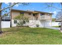 Beautiful home with a balcony, white picket fence, and well-maintained landscaping at 412 Manor Blvd, Palm Harbor, FL 34683